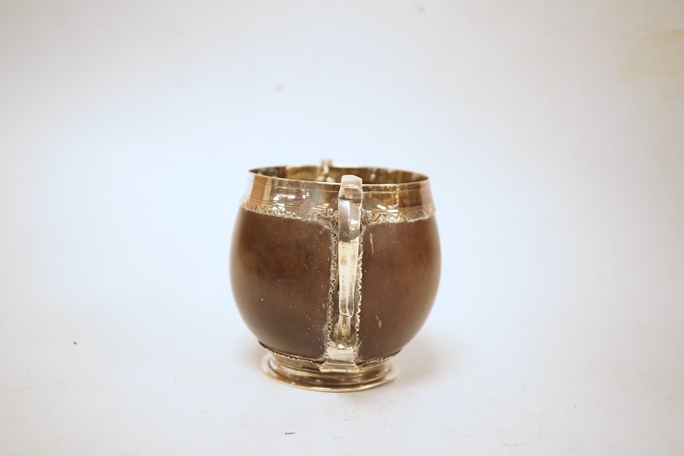 A late 19th/early 20th century white metal mounted two handled coconut cup, with engraved mounts and initials 'A IL', height 10cm (unmarked).